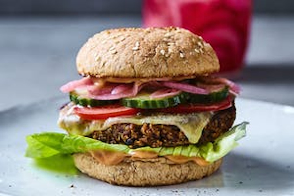 Vegeburgeri mustapapupihvillä Vegeburgeri, jossa salaattia, kurkkua, tomaattia, punasipulia ja juustoa